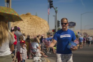 Exchange Club member Brad Cederburg handing out flags at the Fourth of July Celebration